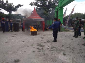 Anggota Satgas TMMD Bojonegoro Membantu Mempraktekkan Pelaksanaan Cara Penanganan Bahaya Kebakaran